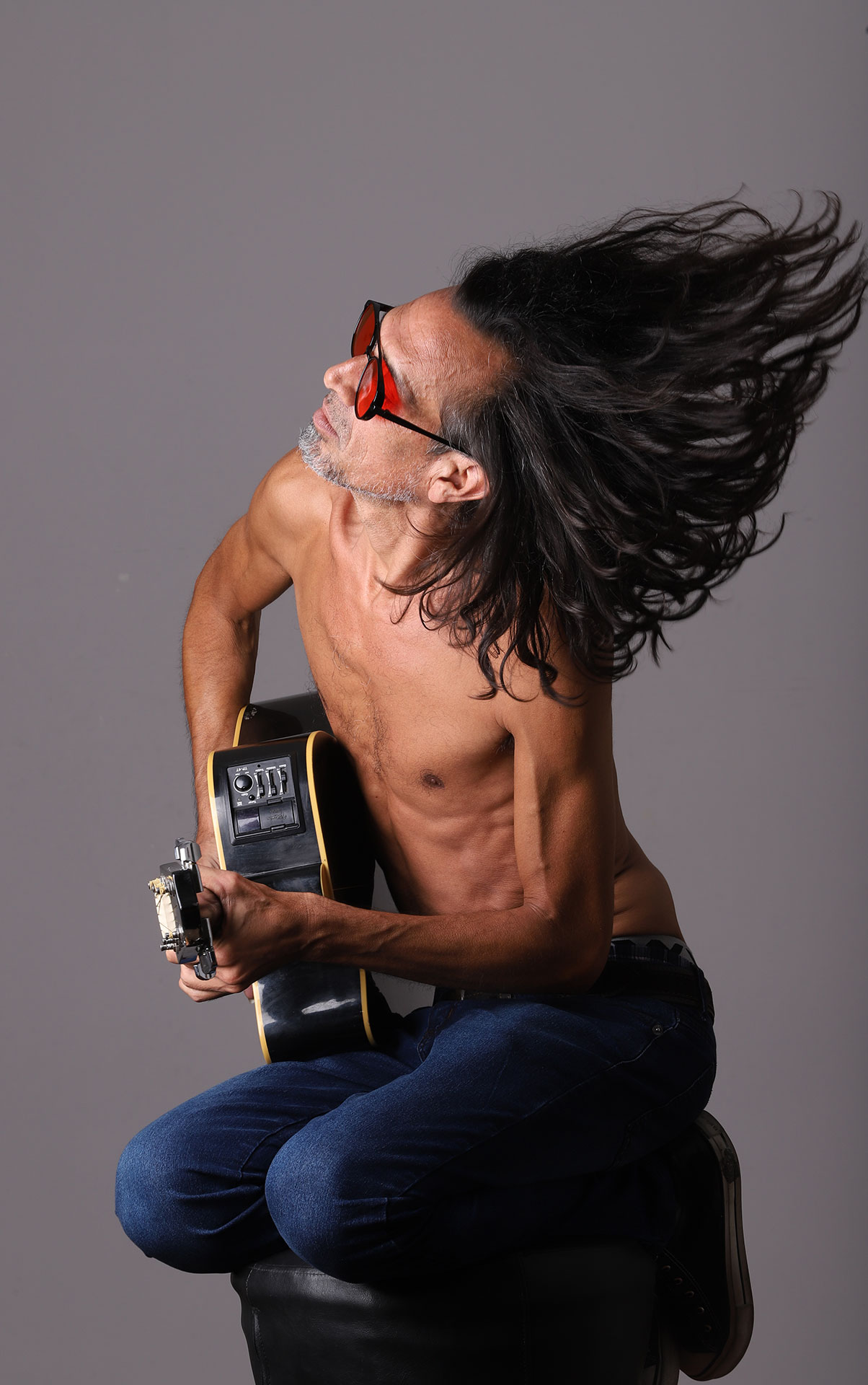 Mario Magno con una guitarra y el pelo en movimiento